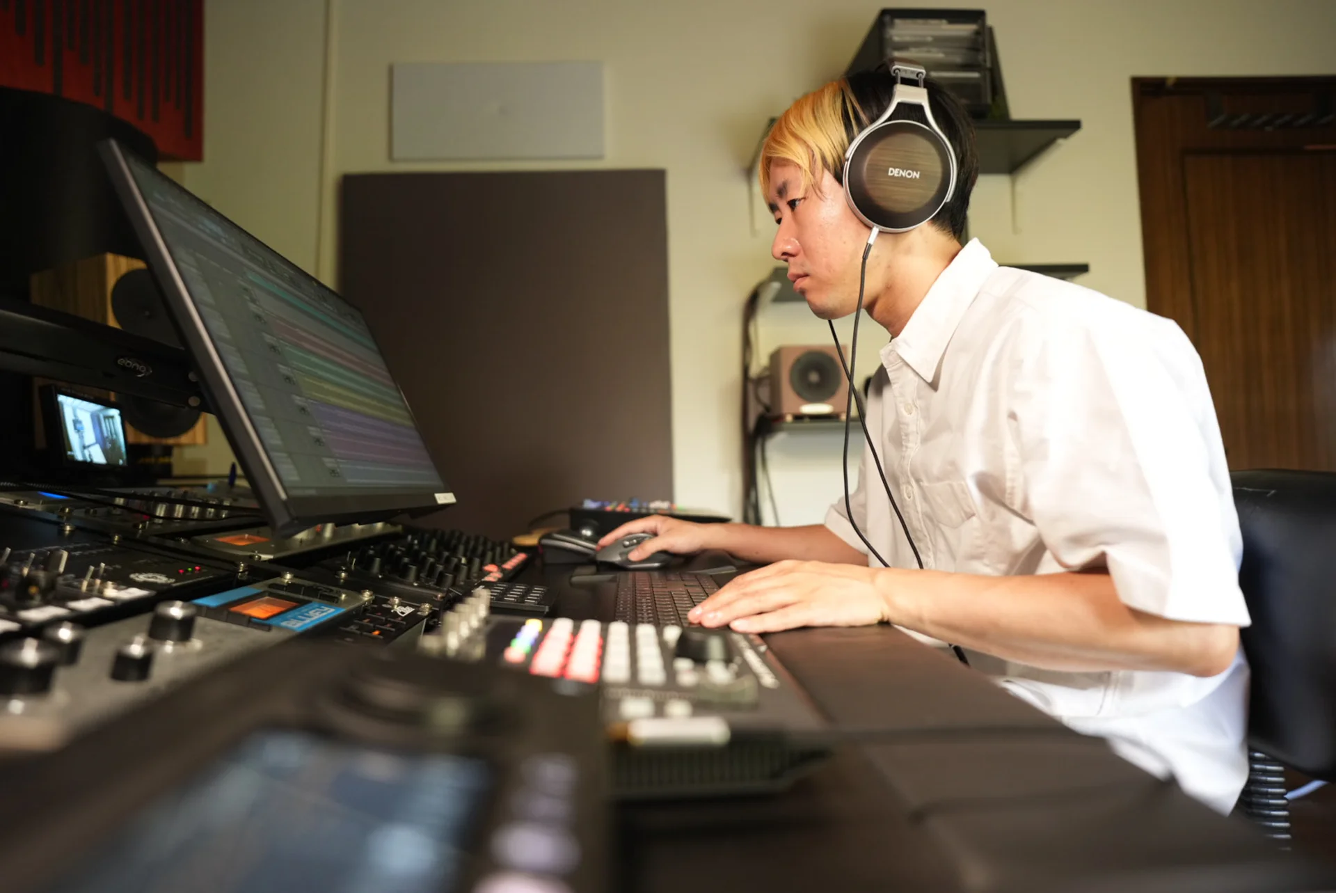 ヘッドホンとコンソールを使って音源を確認するエンジニア