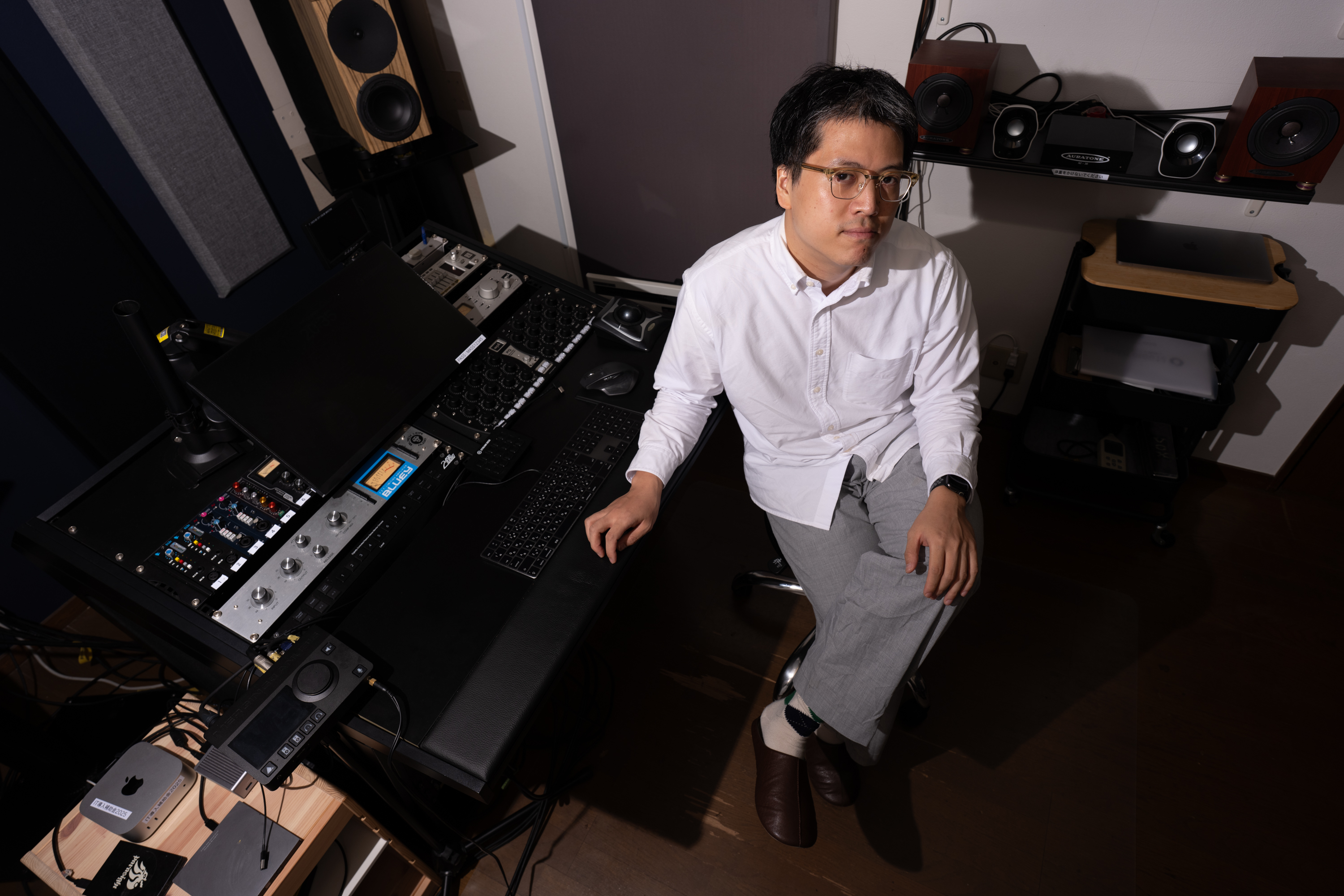 Studio MASSのコントロールルームで制作卓の前に座る伊永拓郎